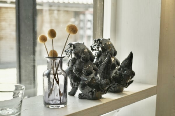 収納棚の上に観葉植物と飾られている黒いシーサー